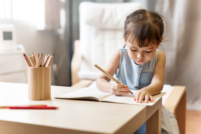 Child sitting at a table drawing